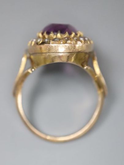 An early 20th century 9ct, amethyst and split pearl set oval dress ring, size N, gross 4.8 grams, (one pearl missing).